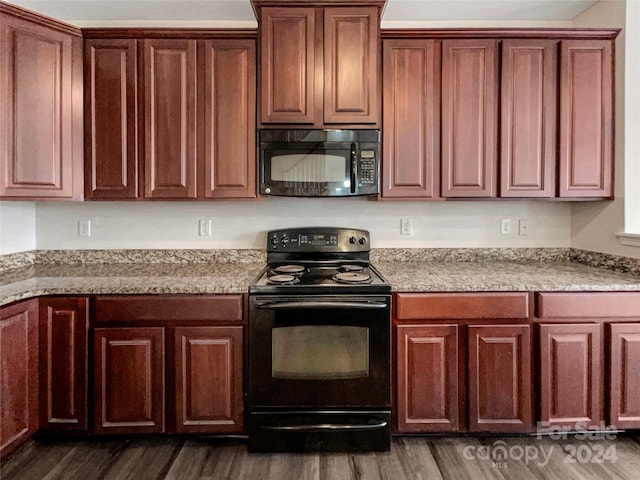 kitchen featuring black appliances, light stone counters, and dark hardwood / wood-style flooring