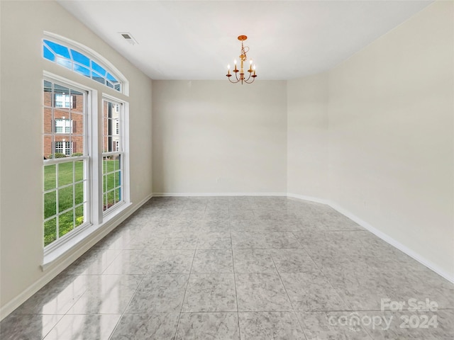 unfurnished room featuring a notable chandelier