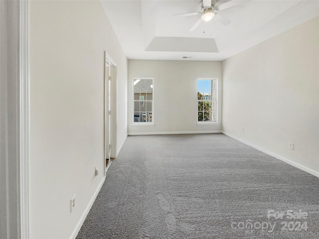 unfurnished room with carpet floors, a raised ceiling, and ceiling fan