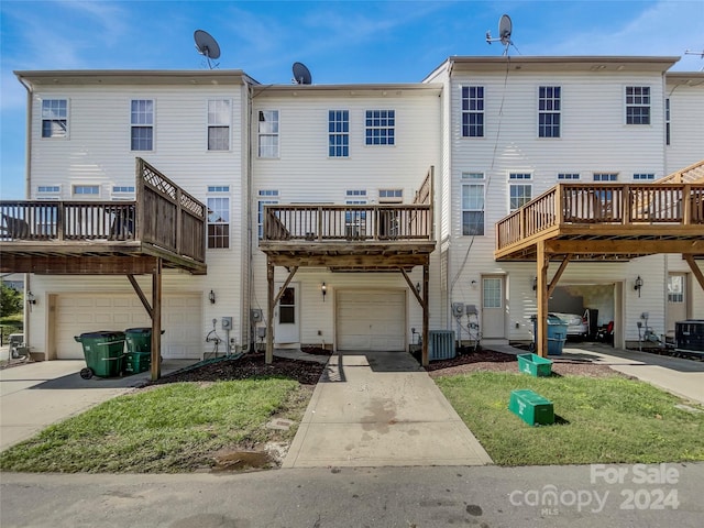 rear view of house featuring a balcony, cooling unit, a garage, and a deck