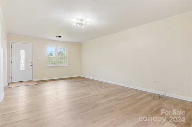 spare room featuring light hardwood / wood-style flooring and crown molding