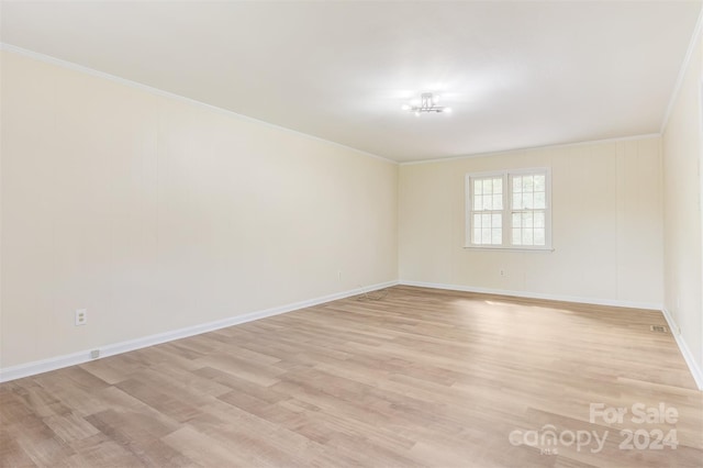 spare room featuring light hardwood / wood-style flooring and crown molding