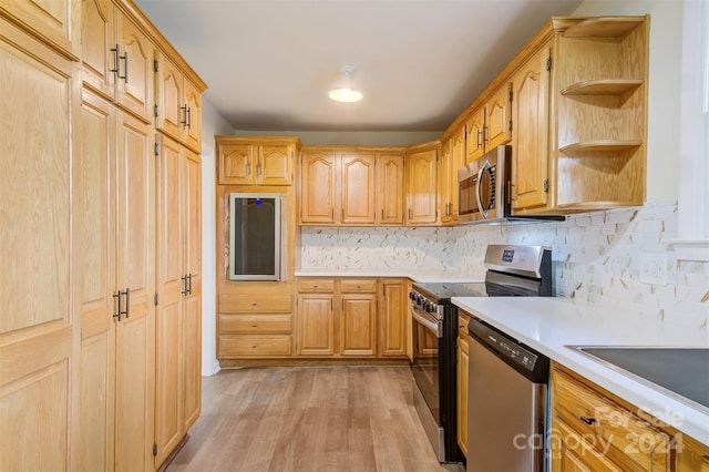 kitchen with light wood-type flooring, backsplash, and stainless steel appliances