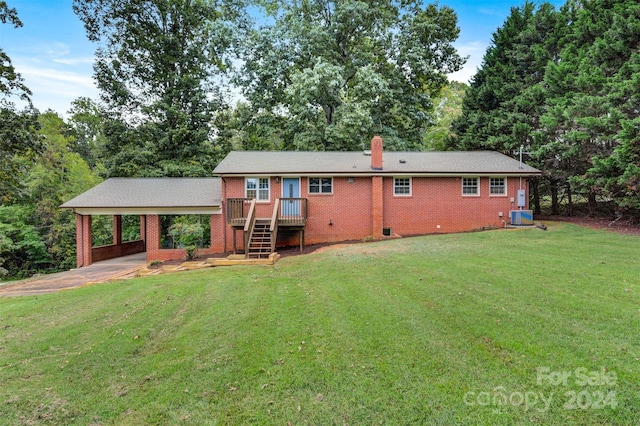 back of house with a yard, a carport, and central air condition unit