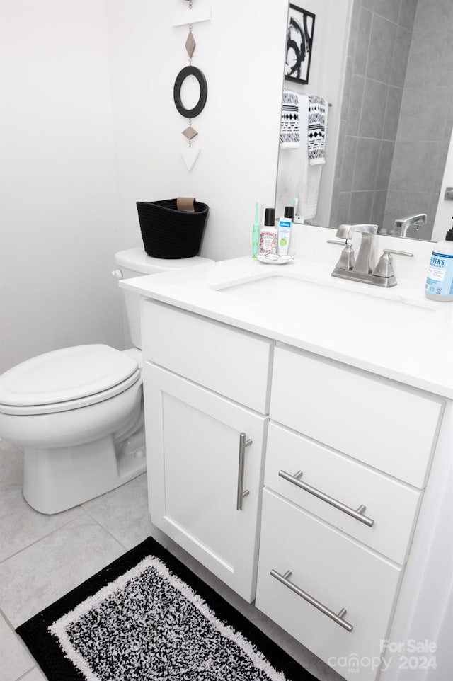 bathroom with tile patterned flooring, vanity, and toilet