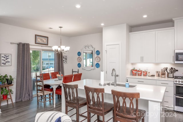 dining room featuring sink, a chandelier, and dark hardwood / wood-style flooring