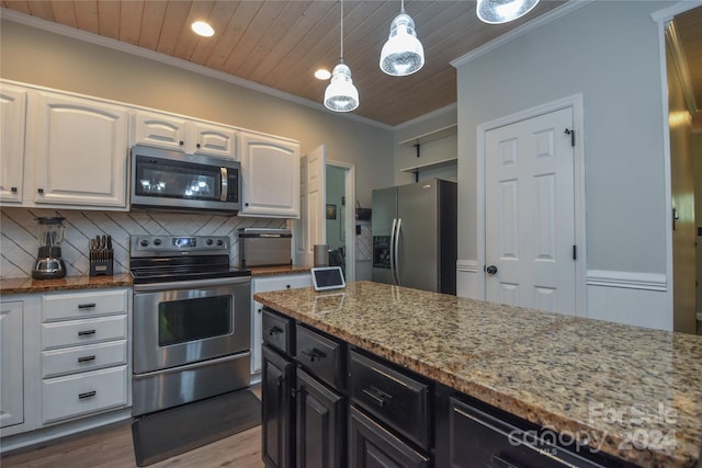 kitchen featuring light stone countertops, white cabinetry, stainless steel appliances, decorative light fixtures, and decorative backsplash