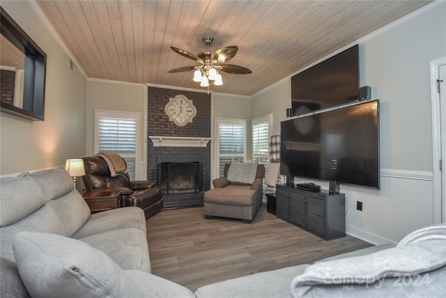 living room featuring ceiling fan, wooden ceiling, light hardwood / wood-style flooring, crown molding, and a fireplace