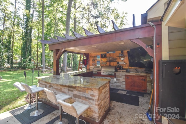 view of patio with a grill, area for grilling, a wet bar, and a pergola