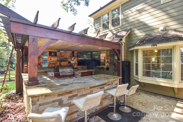 view of patio with a pergola, a grill, exterior kitchen, and an outdoor bar