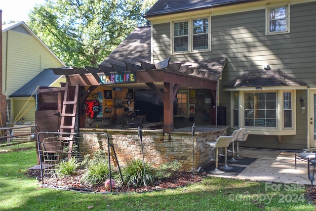 back of house featuring a bar, a patio area, and a pergola