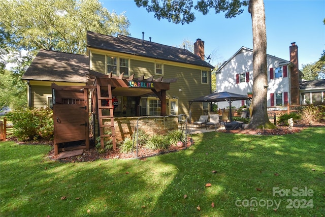 back of property with a pergola and a lawn