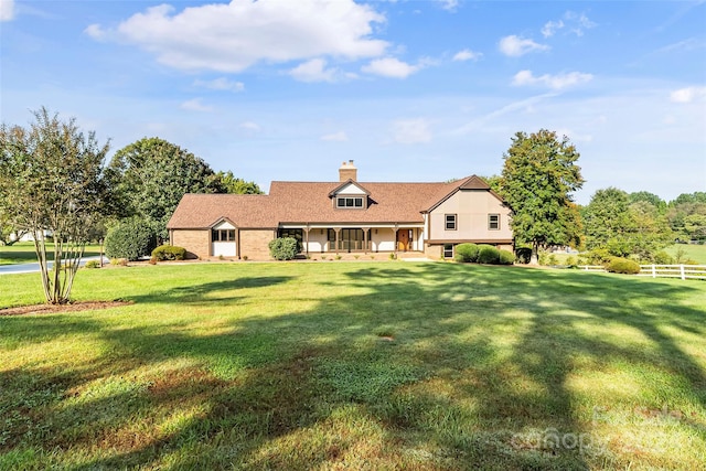 cape cod home featuring a front yard