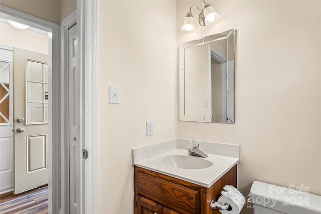 bathroom with vanity, toilet, and wood-type flooring