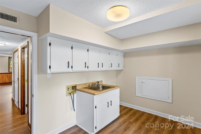 laundry area featuring hookup for a washing machine, a textured ceiling, dark wood-type flooring, and sink