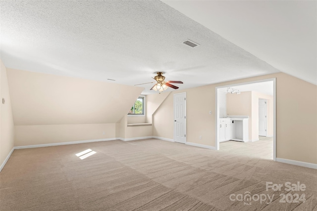 bonus room with a textured ceiling, ceiling fan, vaulted ceiling, and light colored carpet