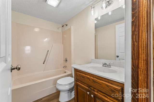 full bathroom with vanity, a textured ceiling, shower / bathtub combination, hardwood / wood-style flooring, and toilet