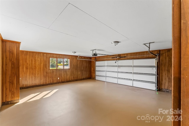 garage featuring a garage door opener and wood walls