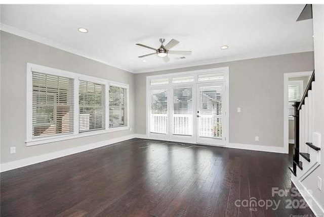 unfurnished living room with plenty of natural light, ceiling fan, crown molding, and dark wood-type flooring