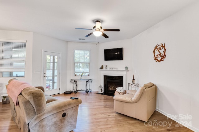 living room with light hardwood / wood-style floors and ceiling fan