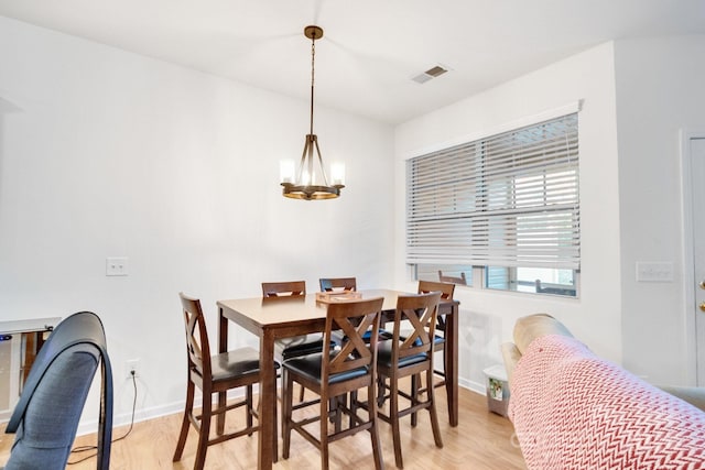 dining space featuring light hardwood / wood-style floors and a notable chandelier