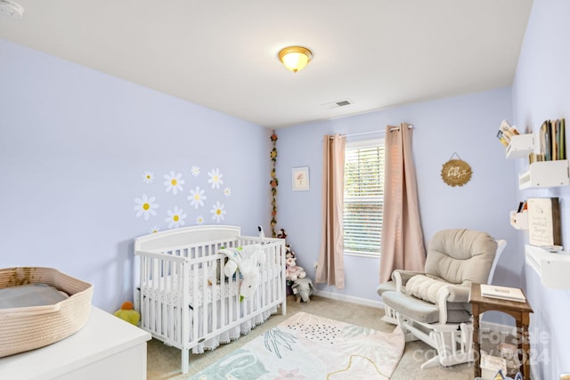 bedroom with light colored carpet and a nursery area