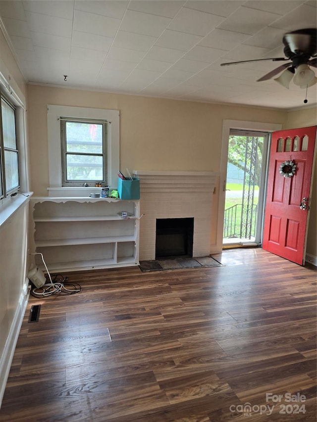 unfurnished living room with a fireplace, dark hardwood / wood-style flooring, and ceiling fan