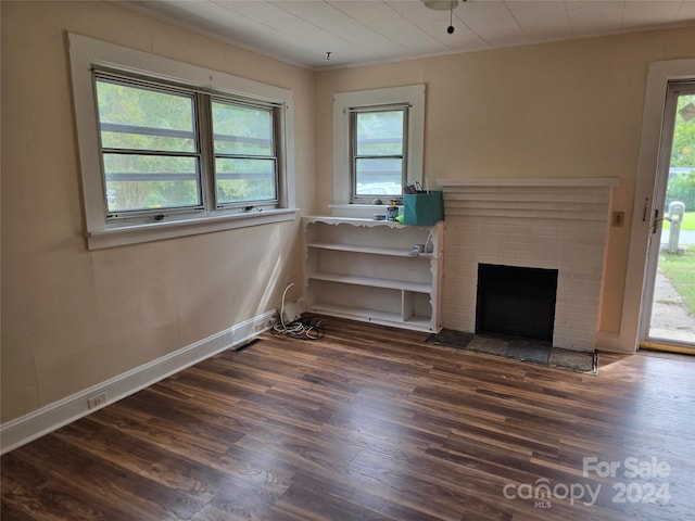 unfurnished living room with a healthy amount of sunlight and dark hardwood / wood-style floors