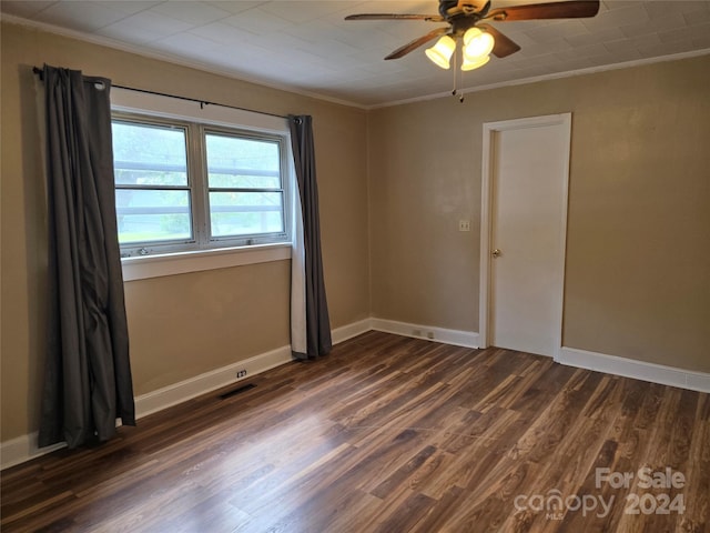 empty room with ornamental molding, ceiling fan, and dark hardwood / wood-style flooring