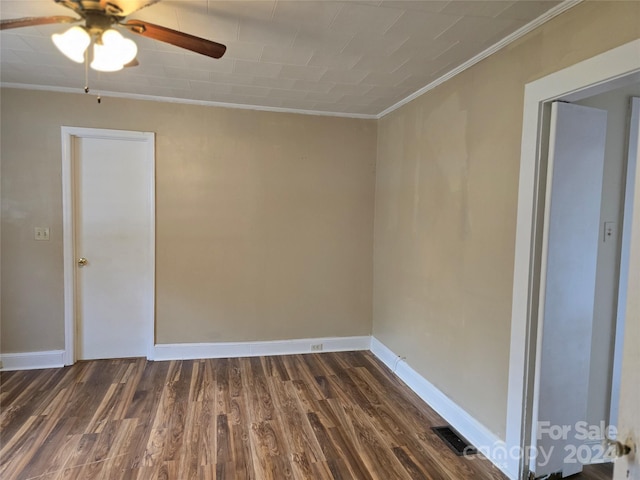 empty room with ceiling fan, crown molding, and dark hardwood / wood-style flooring