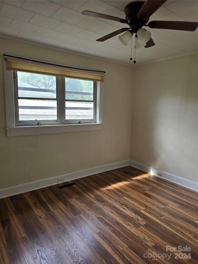 unfurnished room featuring ceiling fan, ornamental molding, and dark wood-type flooring