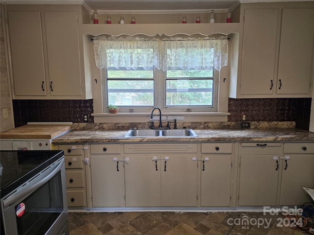 kitchen with sink, white cabinetry, backsplash, crown molding, and stainless steel electric range