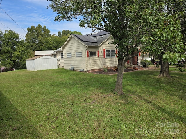 view of side of home with a shed and a lawn