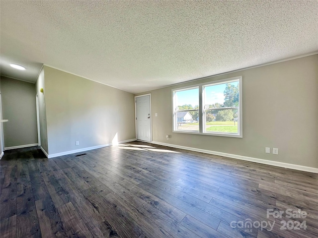 empty room featuring a textured ceiling and dark hardwood / wood-style flooring