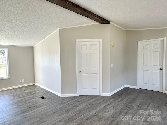 empty room featuring ornamental molding, a textured ceiling, beam ceiling, and dark wood-type flooring