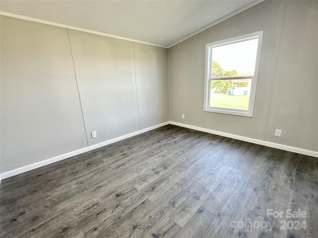 unfurnished room featuring crown molding, vaulted ceiling, and dark hardwood / wood-style floors