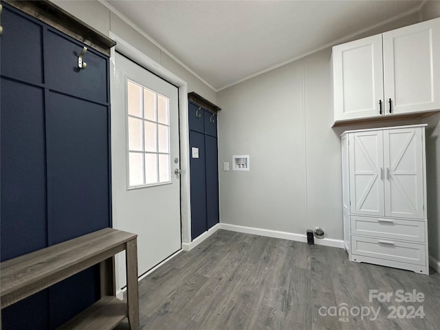 interior space with ornamental molding, washer hookup, dark wood-type flooring, and cabinets