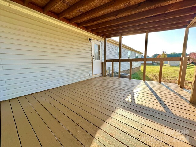 wooden deck featuring a lawn