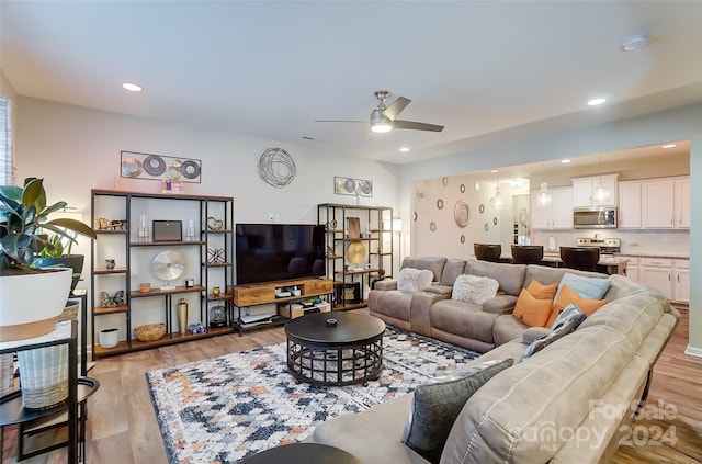 living room with light hardwood / wood-style flooring and ceiling fan