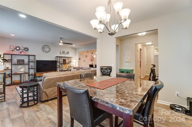 dining space with light hardwood / wood-style flooring and ceiling fan with notable chandelier