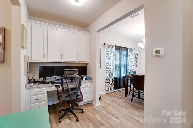 office space featuring light hardwood / wood-style floors and built in desk