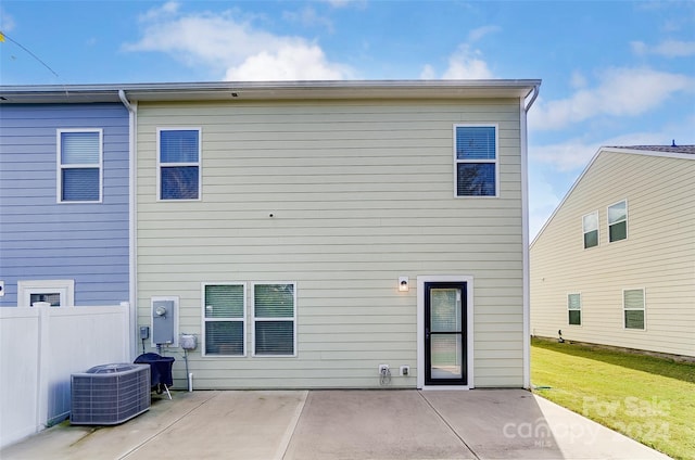 rear view of house featuring a lawn, a patio area, and central AC unit