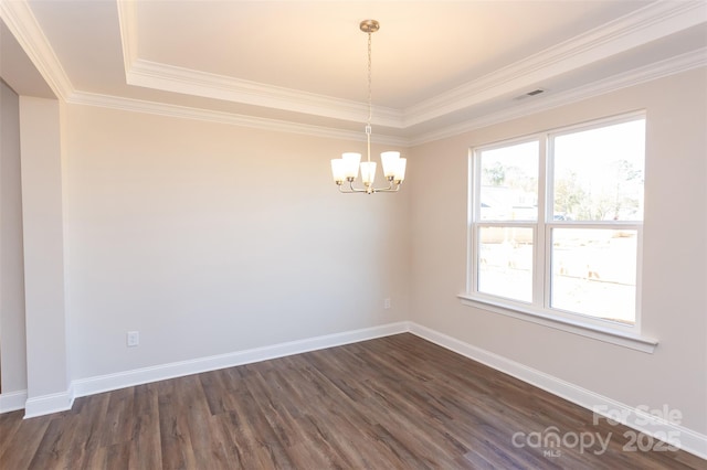 empty room with dark wood-type flooring, ornamental molding, a chandelier, and a raised ceiling