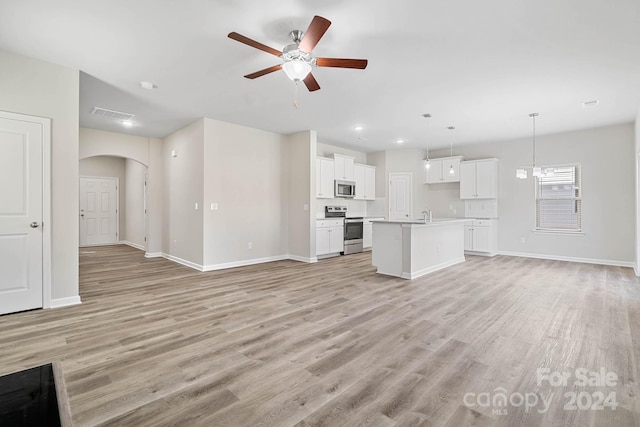 unfurnished living room with light wood-type flooring, ceiling fan, and sink