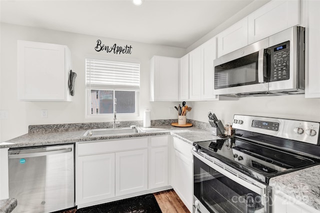 kitchen with sink, white cabinetry, light hardwood / wood-style floors, and appliances with stainless steel finishes