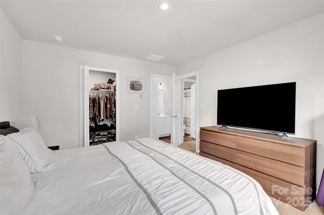 bedroom with a walk in closet, a closet, and ensuite bath