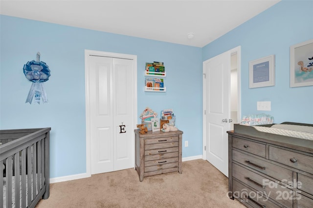 bedroom with light colored carpet, a closet, and baseboards