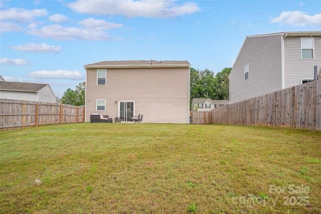 rear view of property with a lawn and a fenced backyard