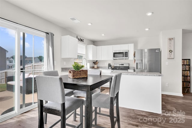 dining room featuring visible vents, recessed lighting, wood finished floors, and baseboards