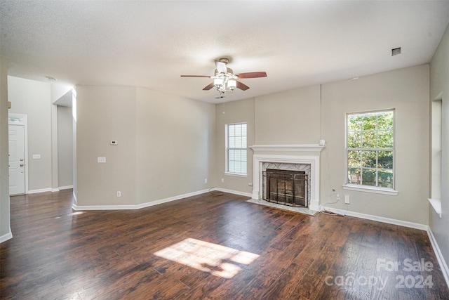 unfurnished living room featuring a wealth of natural light, dark hardwood / wood-style floors, and a high end fireplace